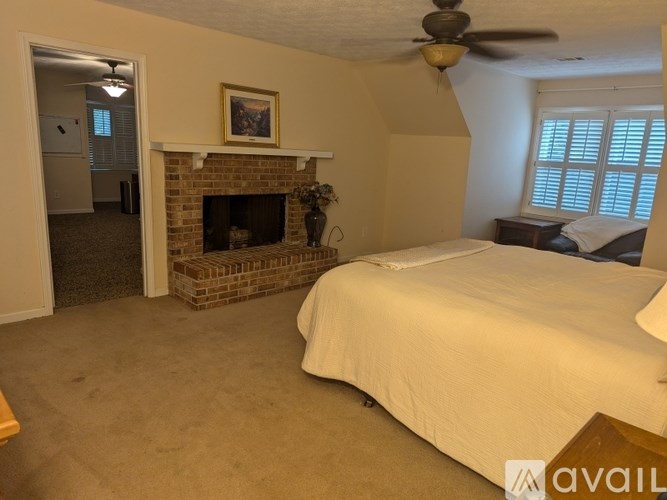 A bedroom with a fireplace and a bed.