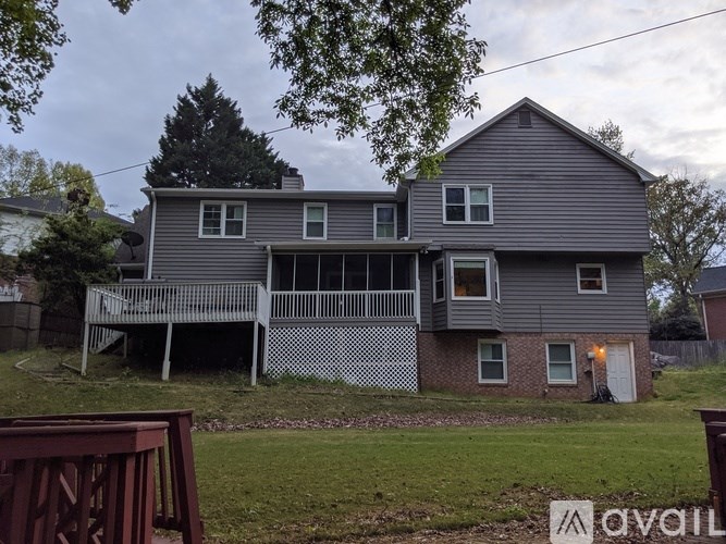 A grey house with a white fence in front.