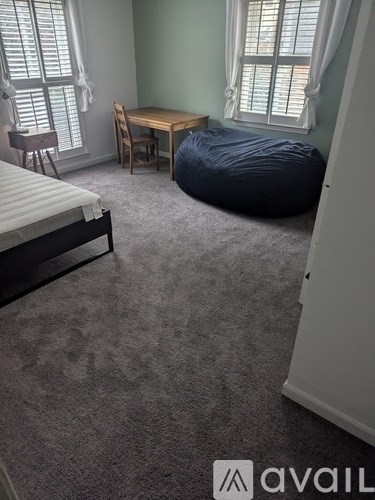 A kitchen pantry with white cabinets and a window with blinds.