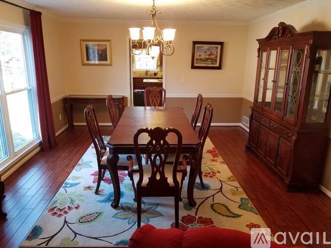A dining room with a wooden table and chairs.