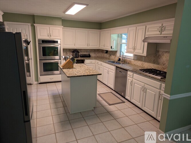 A kitchen with white cabinets and a granite countertop.