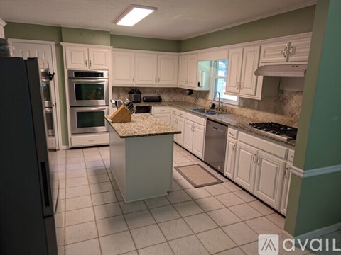 A kitchen with white cabinets and a granite countertop.