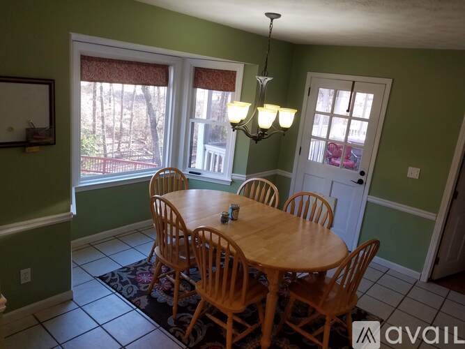 A dining room with a table and chairs.