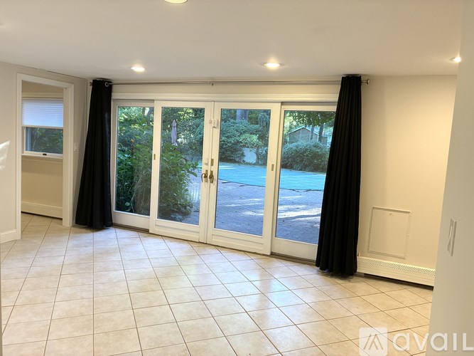 A room with a large sliding door and a tiled floor.