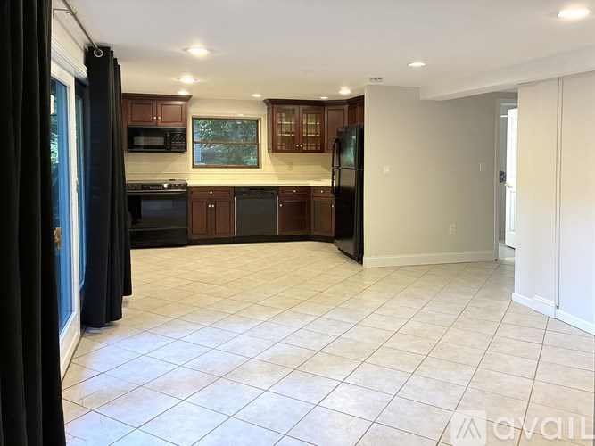 A kitchen with black appliances and wooden cabinets.