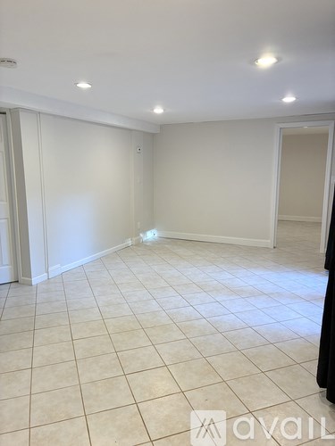 A room with white walls and tiled flooring, with a logo that reads "avail" in the bottom right corner.