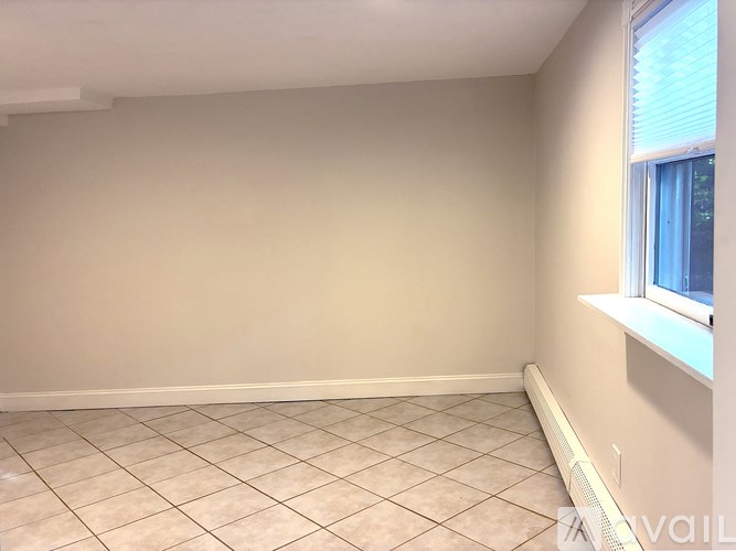 A room with a window and tiled flooring.