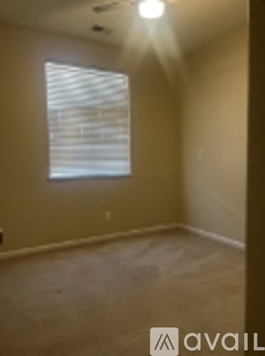 A room with a window and sunlight shining through.