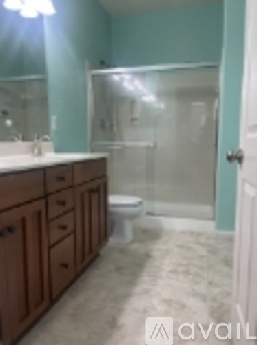 A bathroom with a toilet, sink, and mirror.