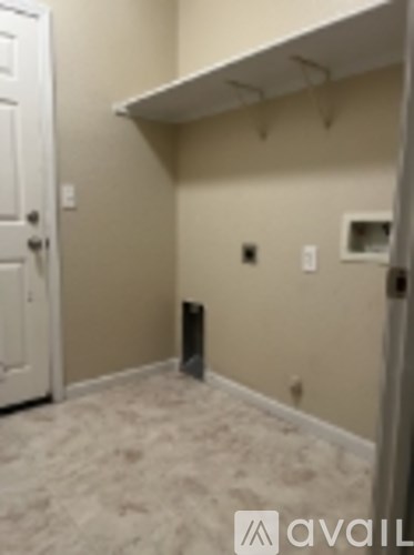 A room with a white door and a white shelf on the wall.