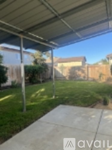 A patio with a metal roof and concrete floor.