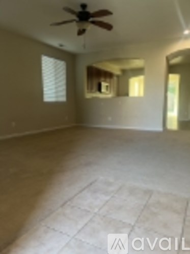 A room with a ceiling fan and tile flooring.