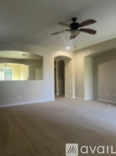 A room with a ceiling fan and wooden flooring.