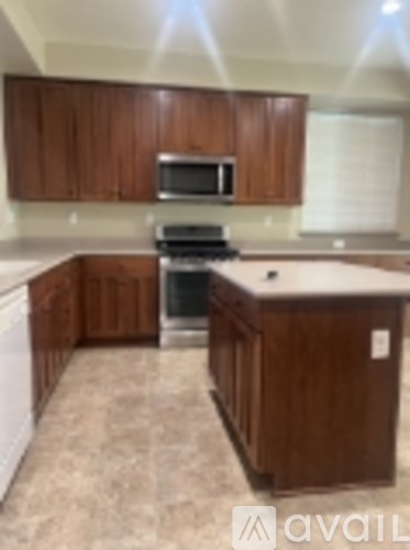 A kitchen with brown cabinets and a white counter top.
