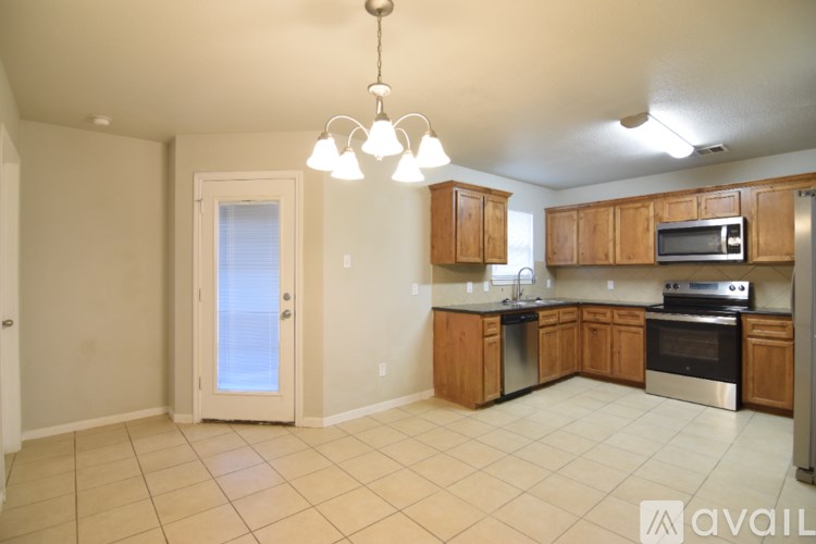 A kitchen with wooden cabinets and stainless steel appliances is available for rent.