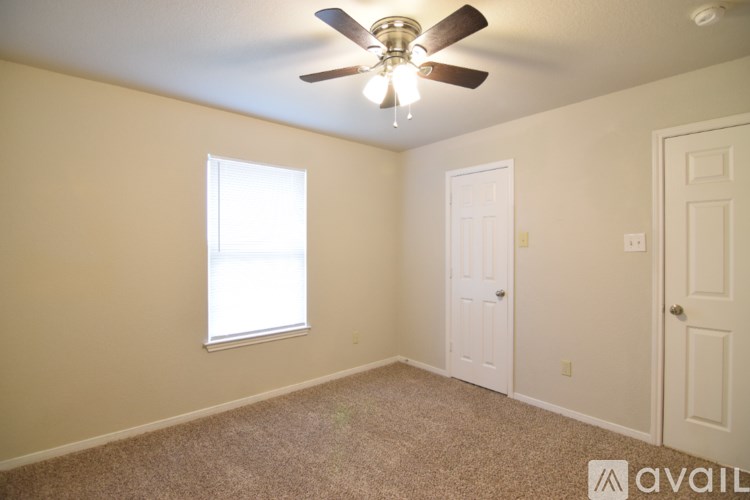A room with a ceiling fan and two doors.