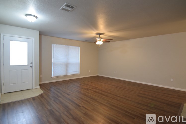 A room with wooden floors and a ceiling fan.