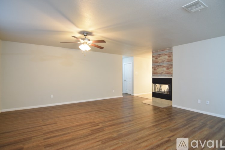A room with a fireplace and a ceiling fan.