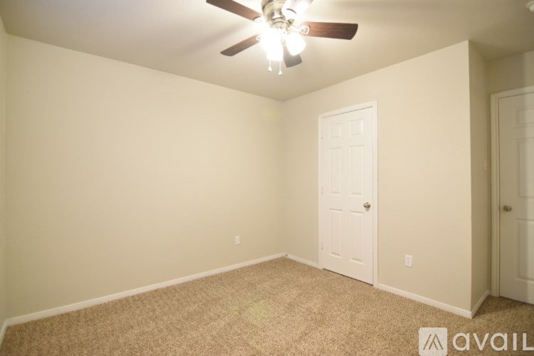 A room with a ceiling fan and two doors.