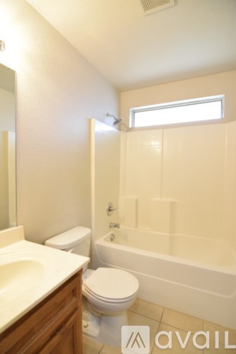 A bathroom with a toilet, sink, and bathtub.