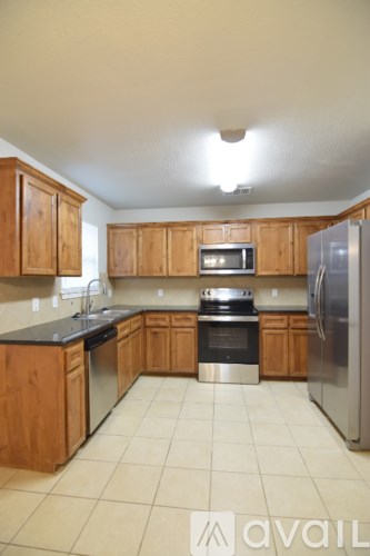 A kitchen with wooden cabinets and stainless steel appliances.
