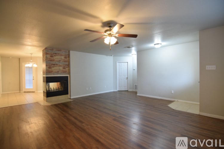 A living room with a fireplace and a ceiling fan.