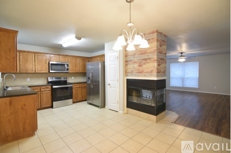A kitchen with a refrigerator, oven, and sink.