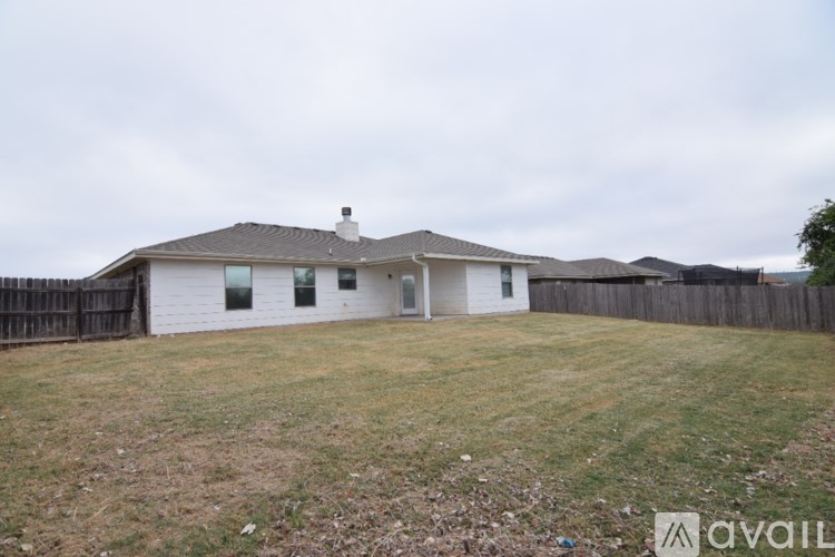 A house with a fence and a yard is available for rent.