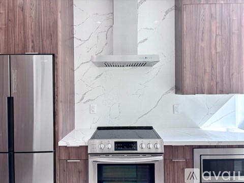 A modern kitchen with a stove and a refrigerator.