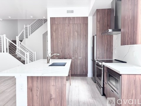 A modern kitchen with wooden cabinets and stainless steel appliances.