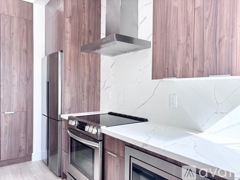 A modern kitchen with a stainless steel oven and wooden cabinets.
