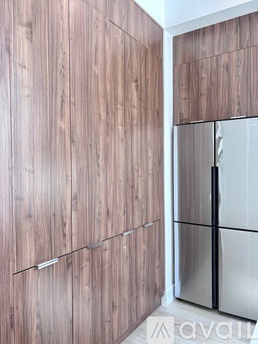 A kitchen with wooden cabinets and a stainless steel refrigerator.