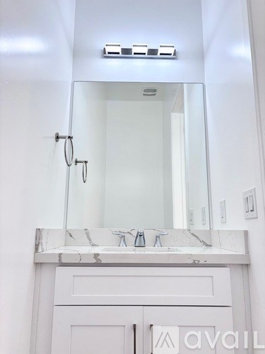 A bathroom with a marble countertop and a large mirror.