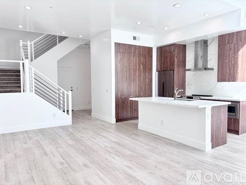 A modern kitchen with a white countertop and wooden cabinets.
