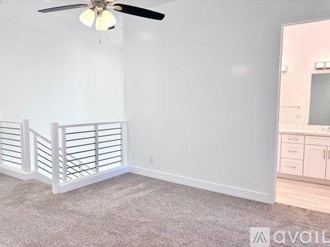 A room with a ceiling fan and a carpeted floor.