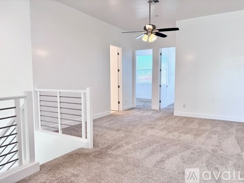 A room with a carpeted floor and a ceiling fan.