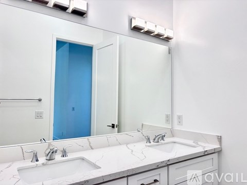 A bathroom with a sink, mirror, and a blue door.