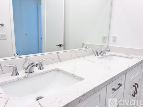 A bathroom with a white sink and marble countertop.