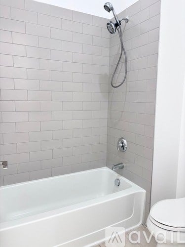 A white bathroom with a white tub and toilet.