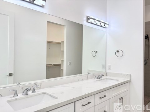 A bathroom with two sinks and a large mirror.