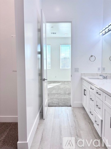 A bathroom with a white vanity and a mirror.