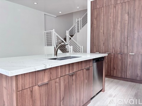 A kitchen with wooden cabinets and a marble countertop.