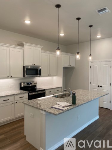 A kitchen with a granite countertop and white cabinets.