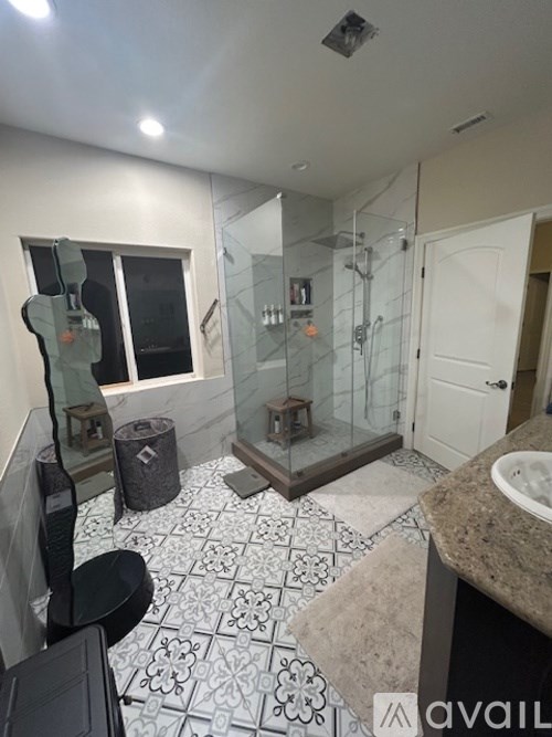 A bathroom with a sink, mirror, and shower.