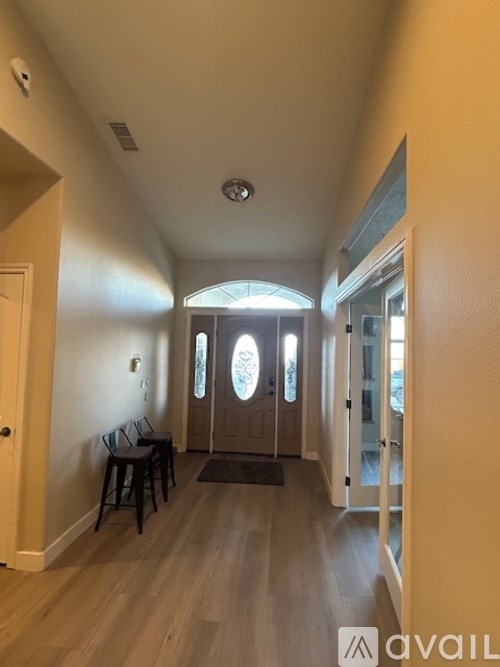 A hallway with a bench and a door.