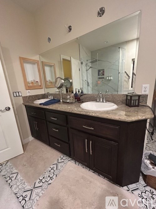 A bathroom with a sink, mirror, and cabinets.