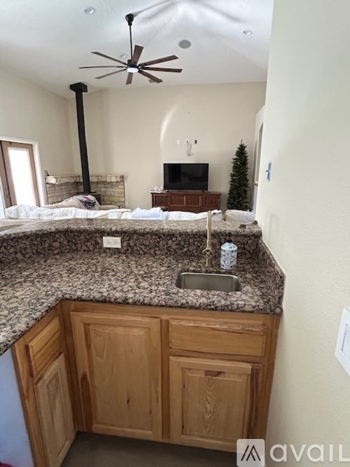A kitchen with a granite countertop and wooden cabinets.