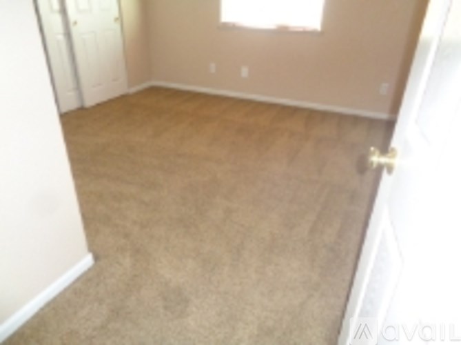 A room with a carpeted floor and a door.