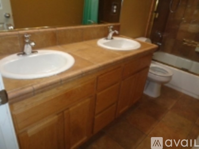 A bathroom with two sinks and a toilet.