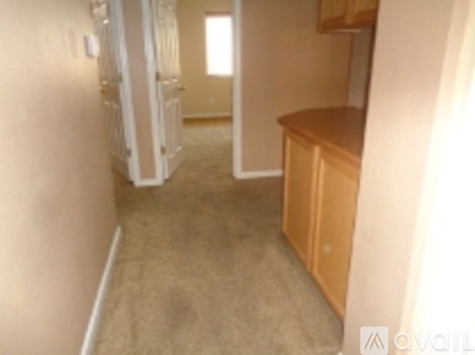 A room with a carpeted floor and a wooden cabinet.